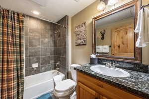 Full bathroom with vanity, toilet, and shower / bathtub combination with curtain