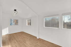 Unfurnished room with lofted ceiling and light wood-type flooring