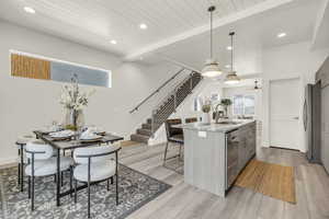 Kitchen with appliances with stainless steel finishes, decorative light fixtures, sink, a kitchen island with sink, and wooden ceiling