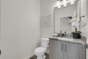 Bathroom with vanity, hardwood / wood-style floors, and toilet