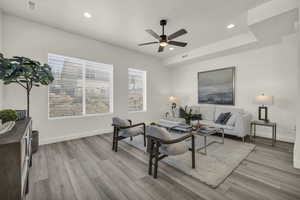 Living room with light hardwood / wood-style flooring and ceiling fan