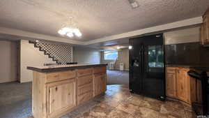 Kitchen featuring radiator, decorative light fixtures, carpet floors, a chandelier, and black appliances