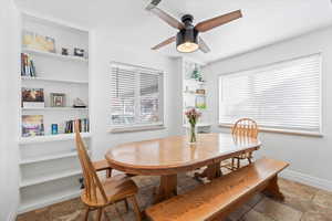 Dining area with built in shelves and ceiling fan