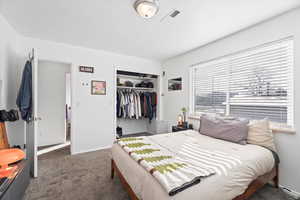 Bedroom featuring a closet and dark colored carpet