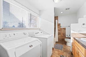 Washroom featuring washing machine and dryer and sink