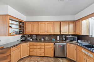 Kitchen with stainless steel appliances, sink, and decorative backsplash