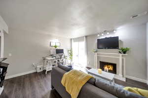 Living room featuring dark hardwood / wood-style flooring and a tile fireplace