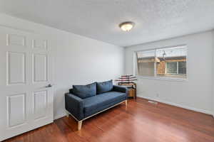 Living area with hardwood / wood-style flooring and a textured ceiling