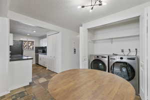 Interior space featuring washer and dryer and a textured ceiling