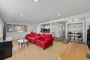 Living room with washer and clothes dryer, a textured ceiling, and light hardwood / wood-style floors