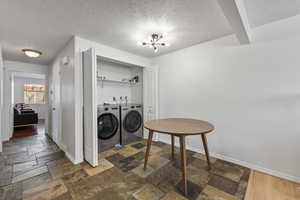 Laundry room with a notable chandelier and washing machine and clothes dryer