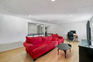 Living room with washer / clothes dryer, hardwood / wood-style flooring, and a textured ceiling