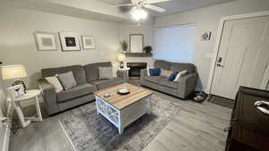 Living room with wood-type flooring and ceiling fan