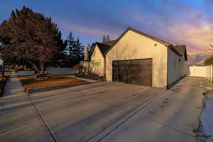 Property exterior at dusk with a garage and a mountain view