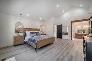 Primary suite featuring high vaulted ceiling and light wood-type flooring