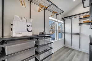 Spacious closet with vaulted ceiling and light wood-type flooring