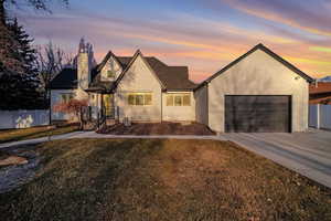 View of front of home with a garage and a lawn