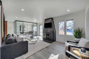 Living room with a fireplace, light hardwood / wood-style floors, and a healthy amount of sunlight