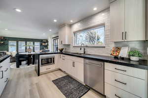 Kitchen with light wood-type flooring, sink, a wealth of natural light, and appliances with stainless steel finishes