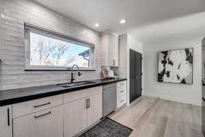 Kitchen featuring tasteful backsplash, a wealth of natural light, sink, and stainless steel dishwasher