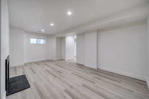 Basement with light hardwood / wood-style floors