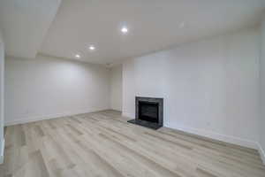 Unfurnished living room with a fireplace and light wood-type flooring