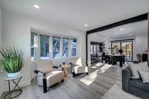 Living room with lofted ceiling with beams and light wood-type flooring