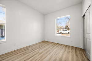 Unfurnished bedroom featuring multiple windows and light hardwood / wood-style floors