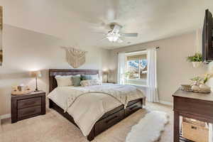 Carpeted bedroom featuring ceiling fan