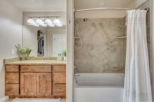 Bathroom with shower / bath combination with curtain and vanity