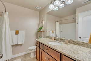 Bathroom featuring vanity, toilet, and a shower with shower curtain