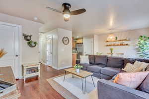 Living room with dark wood-type flooring and ceiling fan