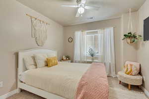 Carpeted bedroom featuring ceiling fan