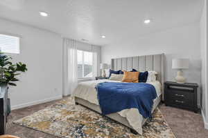 Bedroom with dark colored carpet and a textured ceiling