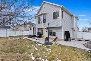 Back of property with a lawn and a patio