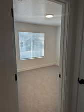 Empty room with carpet floors and a textured ceiling