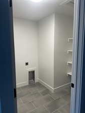 Laundry area with hookup for an electric dryer and dark tile patterned floors