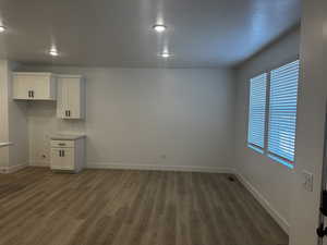 Interior space featuring a textured ceiling, dark hardwood / wood-style floors, and white cabinets