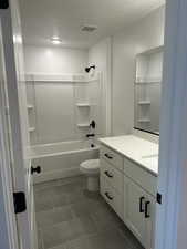 Full bathroom featuring vanity, shower / tub combination, toilet, and a textured ceiling