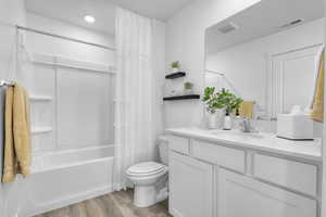 Full bathroom featuring shower / bath combo, hardwood / wood-style floors, vanity, and toilet