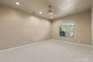 Unfurnished room with ceiling fan and light colored carpet