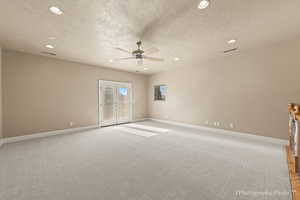 Unfurnished room featuring french doors, light carpet, and a textured ceiling