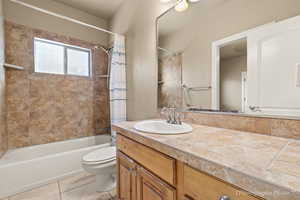 Full bathroom featuring tile patterned flooring, vanity, shower / tub combo, and toilet