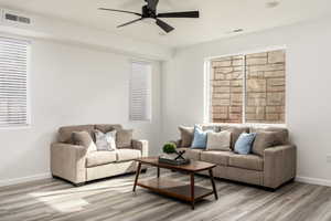 Living room with ceiling fan, plenty of natural light, and light hardwood / wood-style floors