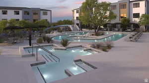 Pool at dusk featuring a community hot tub, pool water feature, and a patio area