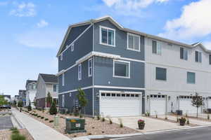 View of front of property with a garage and central air condition unit