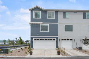 View of front facade with a garage and central AC