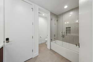 Bathroom featuring tile patterned floors, shower / bath combination with glass door, and toilet