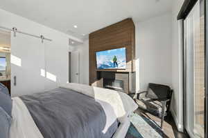 Primary bedroom with linear fireplace and barn door bath ensuite designed for comfort and privacy