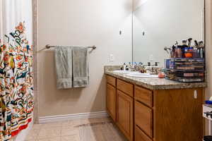 Bathroom featuring tile patterned flooring, a shower with shower curtain, and vanity